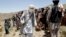 FILE - Members of a Taliban breakaway faction walk during a gathering, in Shindand district of Herat province, Afghanistan, May 27, 2016.