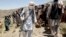 FILE - Members of a Taliban breakaway faction walk during a gathering, in Shindand district of Herat province, Afghanistan, May 27, 2016.