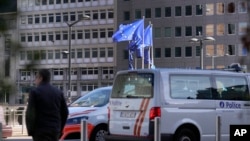 Bendera Uni Eropa berkibar tertiup angin saat mobil polisi diparkir di depan gedung Dewan Eropa, setelah penembakan di pusat kota Brussel, Selasa, 17 Oktober 2023. (AP/Virginia Mayo)