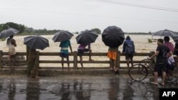 Nepali people watch water flow during heavy rains at Saptari district, 300 kilometers from Kathmandu, Aug. 12, 2017.