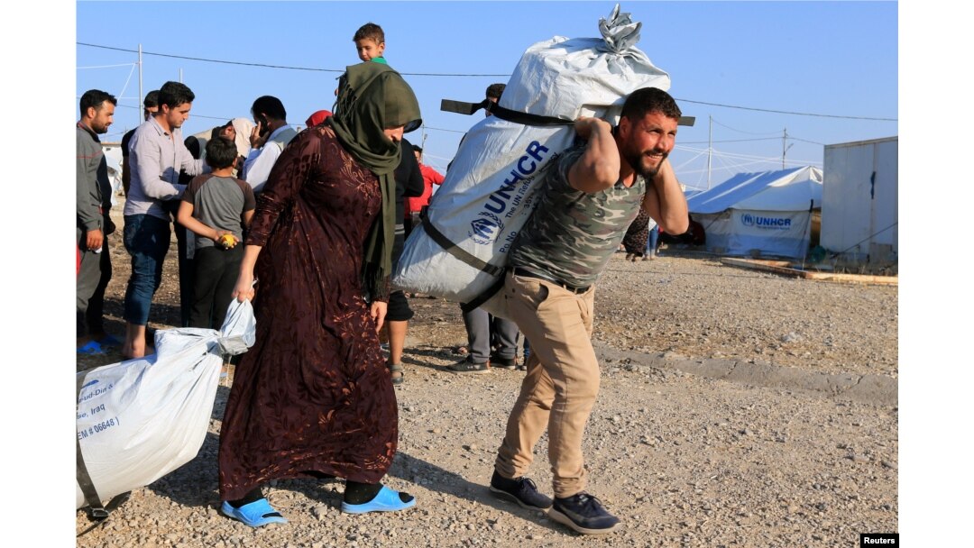 Sirijske porodice, koje su izbjegle nasilje nakon turske ofanzive u Siriji, primaju pomoć u izbjegličkom kampu Bardarash na periferiji Dohuka, Irak, 22. oktobra 2019. godine.