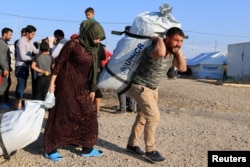 Sirijske porodice, koje su izbjegle nasilje nakon turske ofanzive u Siriji, primaju pomoć u izbjegličkom kampu Bardarash na periferiji Dohuka, Irak, 22. oktobra 2019. godine.