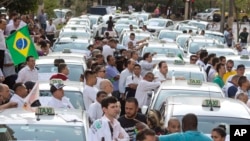 Taxi drivers block a street to protest the Uber ride-sharing service outside city council headquarters in downtown Sao Paulo, Brazil, Sept. 9, 2015.