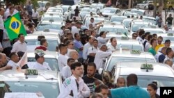 Taxi drivers block a street to protest the Uber ride-sharing service outside city council headquarters in downtown Sao Paulo, Brazil, Sept. 9, 2015.