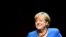 Former German Chancellor Angela Merkel talks with author Alexander Osang, in Berlin