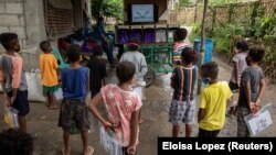 Aeta students watch instructional videos on the makeshift rickshaw for Aeta community distance learning amid the COVID-19 pandemic, in Porac, Pampanga, Philippines, October 12, 2020. (REUTERS/Eloisa Lopez)