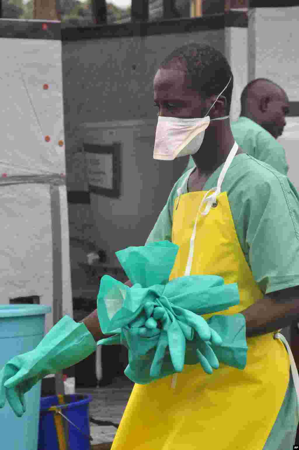 A health worker carries gloves at an Ebola treatment center, Monrovia, Liberia, Aug. 18, 2014.&nbsp;