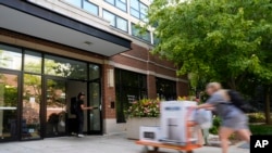 FILE - A student delivers packages to the dormitory at DePaul University in Chicago, Wednesday, Aug. 28, 2024.