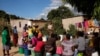 FILE - Letwin Mhande awaits her turn to load an allocation of four buckets of water per family per day at a community run borehole in Epworth, an informal settlement East of Harare, May 23 2024.