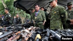 Presiden Filipina Rodrigo Duterte memeriksa senjata api bersama dengan Kepala Angkatan Bersenjata Filipina Eduardo Ano dalam kunjungannya ke kamp militer di Marawi city, selatan Filipina. Pengamat terorisme UI Ridwan Habib mengatakan terdapat bukti adanya jaringan Marawi di Filipina selatan yang terhubung dengan kelompok-kelompok pro-ISIS di Indonesia