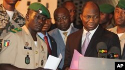 Coup leader Capt. Amadou Haya Sanogo, left, stands with Burkina Faso FM Djibrill Bassole, right, as they address the media at junta headquarters in Kati, outside Bamako, Mali, April 6, 2012.