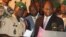 Coup leader Capt. Amadou Haya Sanogo, left, stands with Burkina Faso Foreign Minister Djibrill Bassole, right, as they address the media at junta headquarters in Kati, outside Bamako, Mali, April 6, 2012.