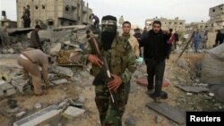 A Palestinian Hamas militant walks in the rubble of the destroyed house of Hamas militant Mohammad Abu Shmala, following an Israeli air strike in Rafah, southern Gaza Strip, November 16, 2012.