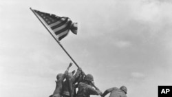 FILE - U.S. Marines raise the American flag atop Mount Suribachi, Iwo Jima, Japan, Feb. 23, 1945.