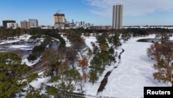 A drone picture shows snow covering Hermann Park and the downtown Houston skyline in the distance in Houston, Texas, Jan. 21, 2025. 