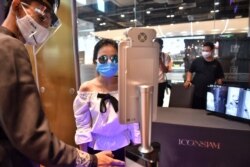 People stand in front of facial recognition software before entering the Icon Siam luxury shopping mall as it reopened after restrictions to halt the spread of the COVID-19 coronavirus were lifted in Bangkok on May 17, 2020.