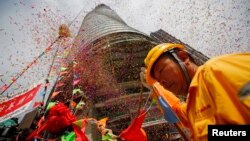 Seorang pekerja menghadiri perayaan "Topping Out" yang menandai pengangkatan tiang terakhir pembangunan menara Shanghai, gedung tertinggi kedua dunia di Pudong, Shanghai (3/8).