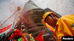 A worker attends the topping out ceremony as crane lift the last piece of steel at the Shanghai Tower, which is undergoing construction at the financial district of Pudong in Shanghai Aug. 3, 2013.