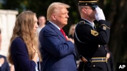 Calon presiden dari Partai Republik, mantan Presiden Donald Trump, meletakkan tangan di dada setelah meletakkan karangan bunga untuk menghormati Sersan Nicole Gee di Makam Prajurit Tak Dikenal di Pemakaman Nasional Arlington, 26 Agustus 2024.