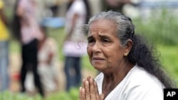 A Sri Lankan tsunami survivor weeps as she places offerings at a mass grave where her relatives were buried, during the commemoration of 2004 tsunami victims in Peraliya, Sri Lanka, (File)