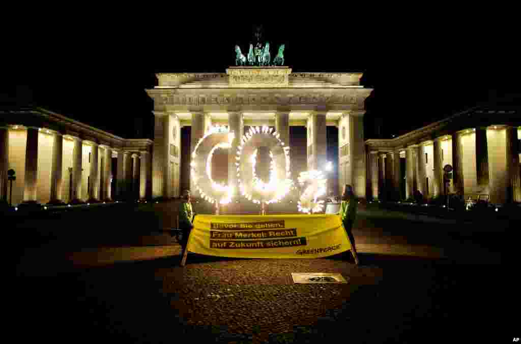 اعتراض فعالان مدافع محیط زیست مشهور به صلح سبزعلیه تغییرات اقلیمی، در مقابل دروازه براندنبورگ در برلین، آلمان