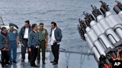 In this June 23, 2016 file photo released by the Indonesian Presidential Office, Indonesian President Joko Widodo, third right, accompanied by Indonesian officials on navy warship KRI Imam Bonjol, at the Natuna Islands, Indonesia.