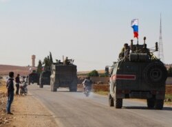 FILE - A convoy of Russian military vehicles heads for the Syrian city of Kobane, Oct. 23, 2019.