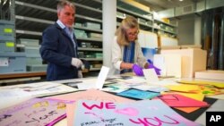 FILE - Jan Ramirez, chief curator at the 9/11 Memorial & Museum, sifts through condolence cards for a victim of 9/11 that were donated to the museum's archive, July 16, 2021, in Jersey City, N.J. 