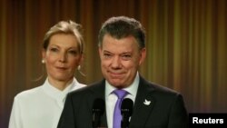 Prezidan kolonbyen an, Juan Manuel Santos, tap souri lè tap anonse laprès li ranpòte Pri Nobèl Lapè 2016 la. (Li te gen bò kote li madanm li, Maria Clemecia de Santos). Foto: Vandredi 7 oktòb 2016.