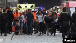 Injured people leave the area after an explosion in Prague, Apr. 29, 2013.