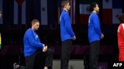 FILE - Race Imboden, left, of the U.S. kneels during the national anthem at the Lima Convention Center, during the Pan American Games Lima 2019, in this Aug. 9, 2019, handout picture released by Lima 2019.