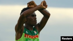 L'Ethiopien Feyisa Lilesa fait un signe pour protester contre le gouvernement éthiopien, lors des JO de Rio, le 21 août 2016.