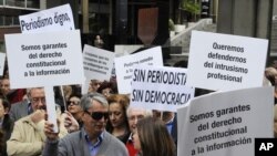 Journalist hold placards reading 'We are guarantors of the constitutional right to information' and 'There is no democracy without journalism' during a demonstration to mark the World Press Freedom Day on May 03, 2012 in Madrid. (AFP)