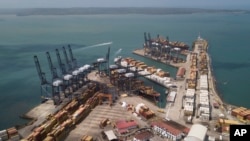 ARCHIVO - Contenedores de carga se apilan mientras grúas cargan y descargan contenedores de buques de carga en el puerto Cristóbal, operado por la Compañía de Puertos de Panamá, en Colón, el 4 de febrero de 2025. 