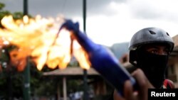 Un manifestante sostiene una bomba molotov durante un enfrentamiento con las fuerzas antidisturbios en una protesta contra el gobierno en Caracas, Venezuela. Julio 22 de 2017.