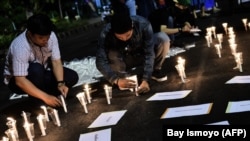 Sejumlah pengunjuk rasa menyalakan lilin dalam demo di depan Istana Kepresidenan di Jakarta untuk memprotes pelaksanaan hukuman mati, pada 28 Juli 2016. (Foto: AFP/Bay Ismoyo) 