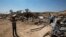 Khader Abu al-Kian (R) and his son walk among the rubble of their family's home which was demolished by Israeli authorities in the village of Atir, August 6, 2013.