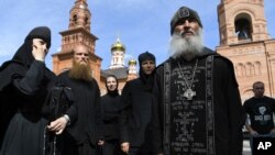 Father Sergiy, a Russian monk who has defied the Russian Orthodox Church's leadership, right, speaks with journalists in Sredneuralsk, Russia, June 17, 2020. 