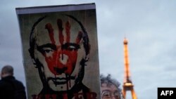 FILE —Protester hold a placard during a demonstration organised by the association "Russie-Libertes" following the death in an arctic prison of the opposition leader Alexei Navalny, at the Esplanade du Trocadero in Paris, on February 22, 2024.