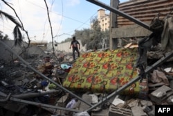 Seorang anak laki-laki berjalan di tengah reruntuhan rumah yang terkena serangan Israel di Deir El-Balah di Jalur Gaza tengah pada 4 Oktober 2024. (Foto: AFP)