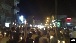 In this citizen journalism image made on a mobile phone Tuesday May 10, 2011 and acquired by the AP, Syrian anti-government protesters carry candles during a rally in the northeastern city of Qamishli, Syria.