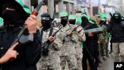 FILE - Masked militants from a military wing of Hamas commemorate the 29th anniversary of their group, in Gaza City, Dec. 14, 2016. 