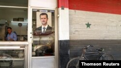 Una foto del presidente de Siria, Bashar al-Assad, se exhibe en la puerta de una carnicería en Damasco. Foto de archivo.