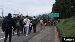 Migrantes caminan a lo largo de una carretera durante una caravana con destino a la frontera norte con Estados Unidos, en las afueras de Tapachula, México, 2 de diciembre de 2024, 2024.