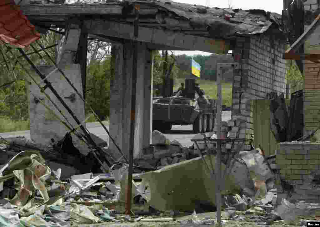A Ukrainian army military armored vehicle is seen through a ruined building on the outskirts of Slovyansk, Aug. 5, 2014.