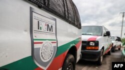 FILE - Vans of Mexico's National Migration Institute (INM) are seen at a checkpoint on the outskirts of Tapachula, Chiapas State, Mexico, June 12, 2019. The head of the National Migration Institute, Tonatiuh Guillén López, has resigned. 