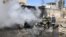 Firefighters hose down a destroyed vehicle at the site of a suicide bomb attack in Kirkuk, Iraq, February 3, 2013. 