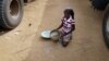 A girl gathers rice spilled from a humanitarian food convoy that arrived from the Malian capital Bamako in the northeastern city of Gao, Jun. 14, 2012. 