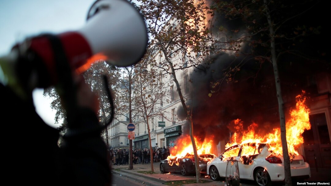 Mobil-mobil terbakar dalam unjuk rasa menentang "RUU Keamanan Global" yang menurut para aktivis akan mempidanakan penyebaran foto wajah polisi dan akan melanggar kebebasan pers di Perancis, Paris, Sabtu 28 November 2020.