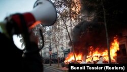 Mobil-mobil terbakar dalam unjuk rasa menentang "RUU Keamanan Global" yang menurut para aktivis akan mempidanakan penyebaran foto wajah polisi dan akan melanggar kebebasan pers di Perancis, Paris, Sabtu 28 November 2020.